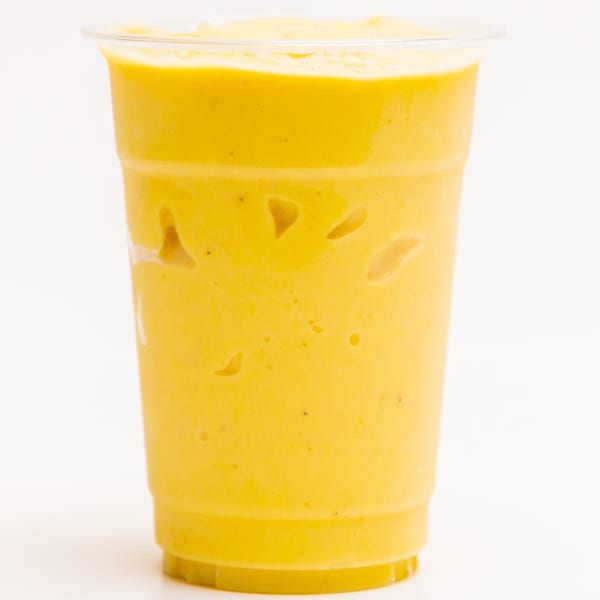 A vibrant yellow Superfood Cafe smoothie in a clear plastic cup, against a white background.