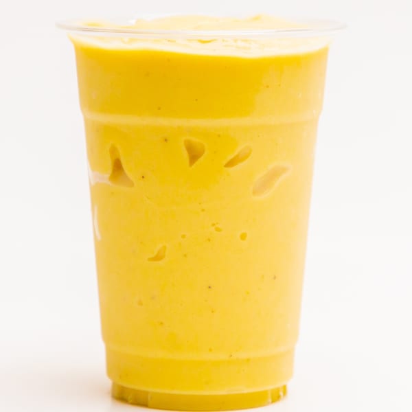 A vibrant yellow Superfood Cafe smoothie in a clear plastic cup, against a white background.