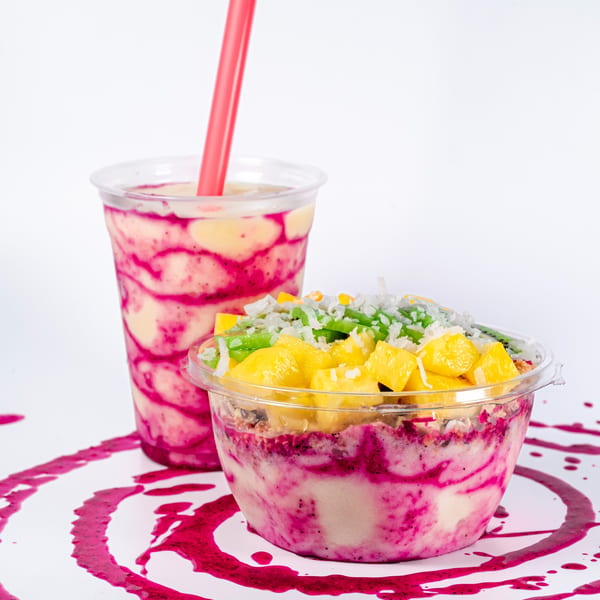 A Superfood Cafe smoothie and a fruit bowl with mango, avocado, and coconut flakes.